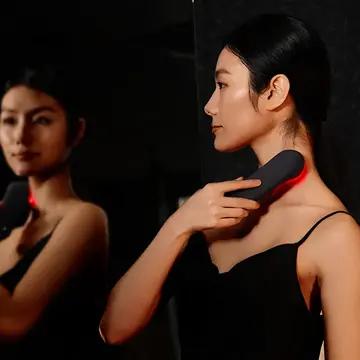 A woman using FAQ 502 full-spectrum red light therapy